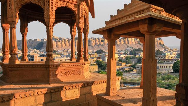 Die "Royal Cenotaphs of Historic Rulers", auch bekannt als "Jaisalmer Chhatris", in Bada Bagh. Im Hintergrund ist die Altstadt von Jaisalmer zu sehen. Rajasthan, Indien.